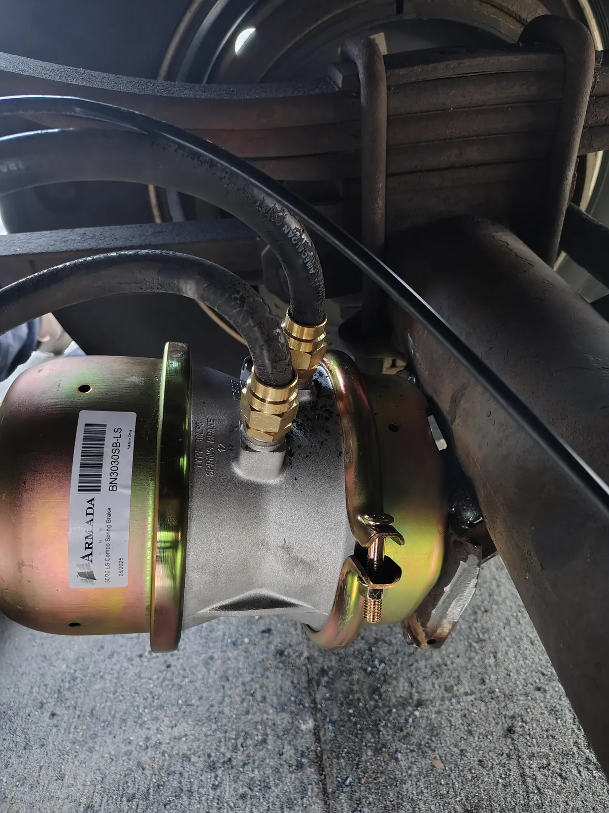 Air brake chamber with connected lines beneath a truck